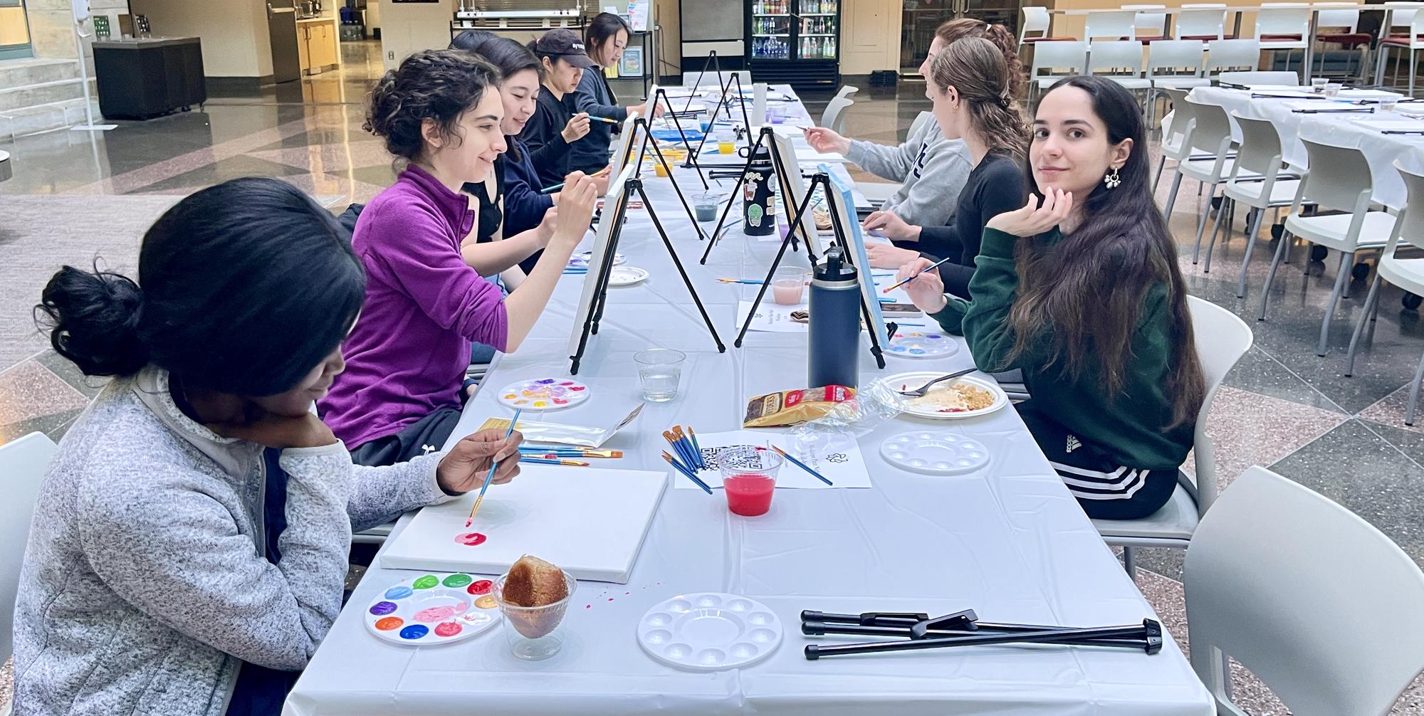 A group of students painting in the TMEC Atrium.