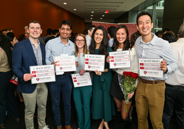 Six MD students, standing side-by-side and smiling, holding "I Matched" signs with their specific match information.