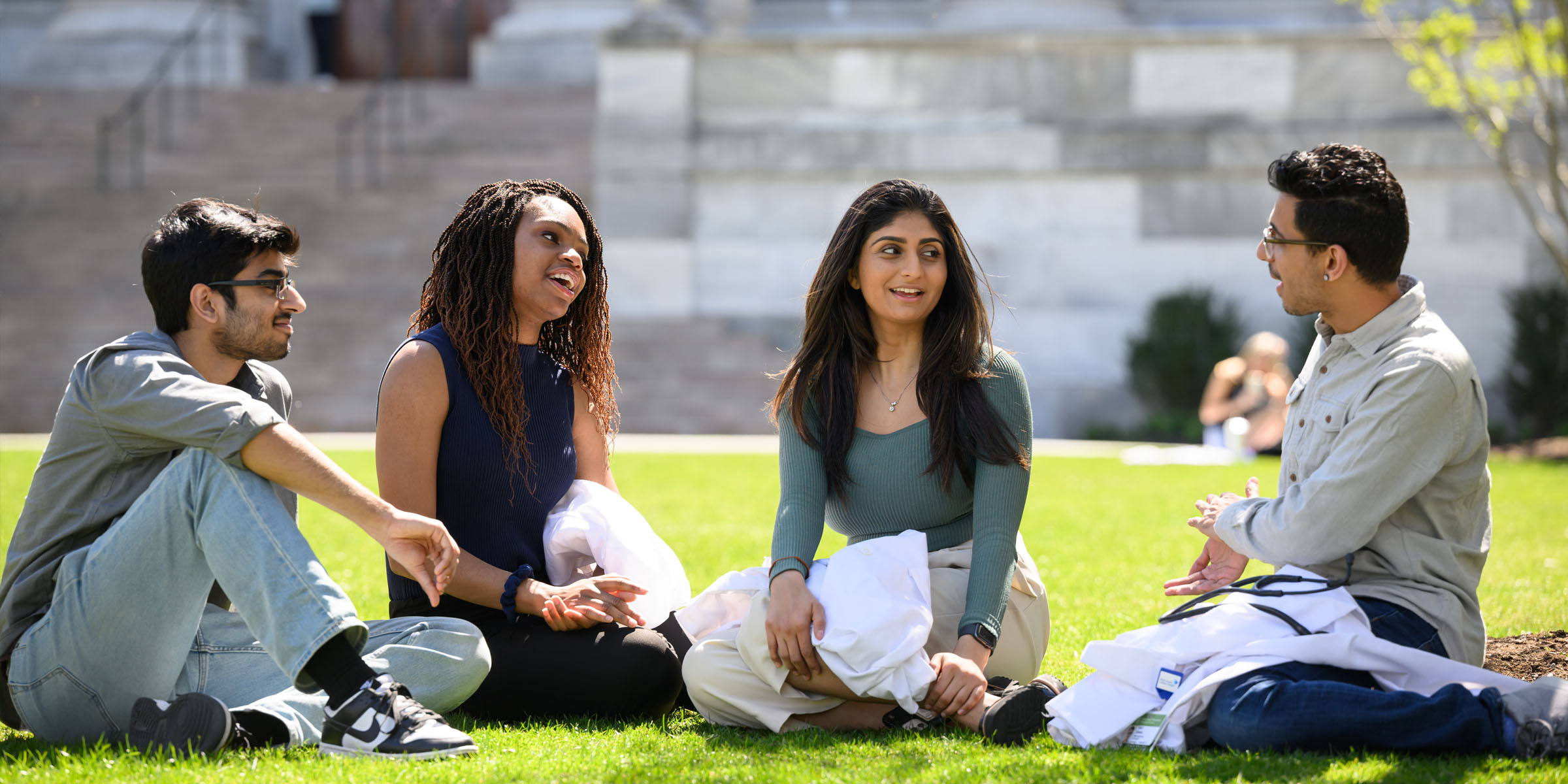 Students sit on the grass outside on the HMS Quad.