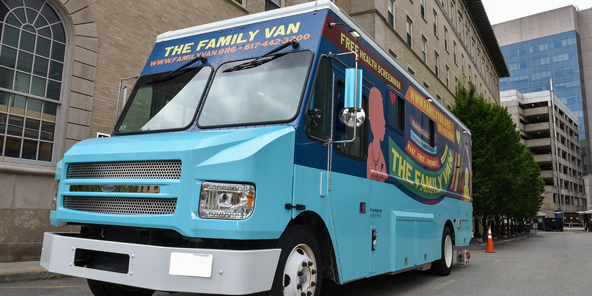 A brightly painted blue mobile clinic van parked on a city street. The side reads “The Family Van” and advertises free health screenings, with the website and phone number displayed above the windshield.