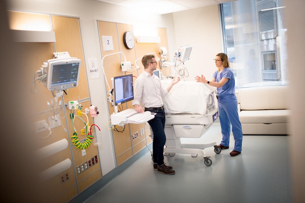 A student and faculty member having a conversation in a clinical skills learning environment.