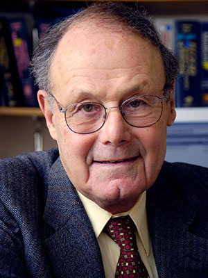 A close-up of a smiling man wearing glasses.