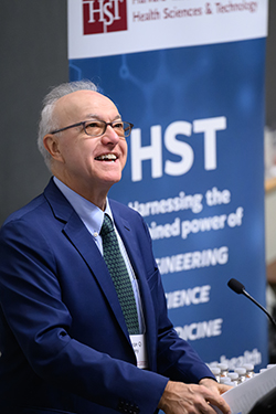 George Q. Daley smiles while speaking to the crowd in front of a banner announcing the HST anniversary celebration