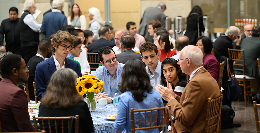 Attendees converse at tables in the TMEC Atrium