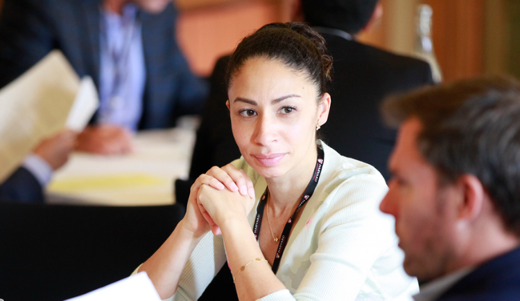 woman with folded hands looking at a man