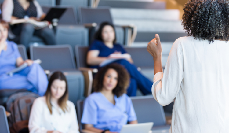 woman in doctor white coat teaching medical students