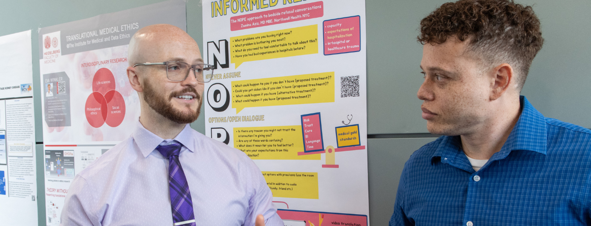 two people standing in front of a poster