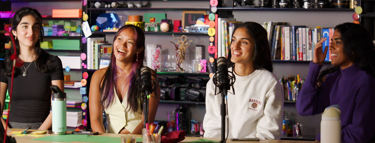 group of people sitting behind a news desk