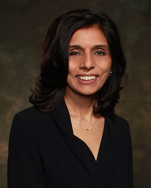 Head and shoulder portrait of a woman with brown hair and brown eyes in a black top