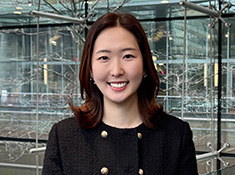 A woman in a double breasted suit jacket smiles