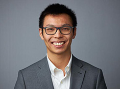 Headshot of a man in a suit wearing glasses