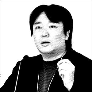 Black and white headshot photo of a young man with dark short hair gesturing with his left hand