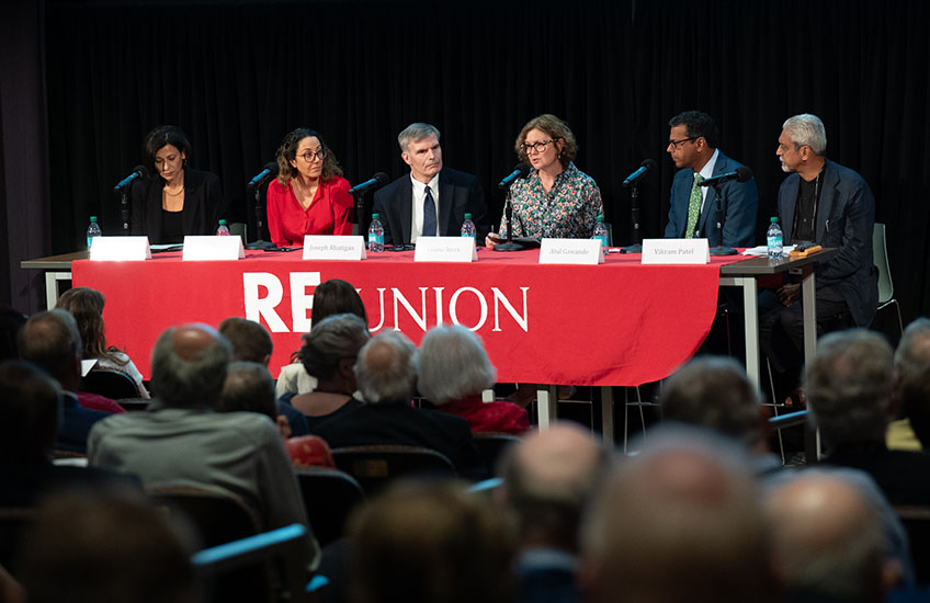 “Reimagining Global Health” panelists sit at a table in front of an audience