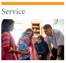 SERVICE: Photo of four adults standing around a child and smiling