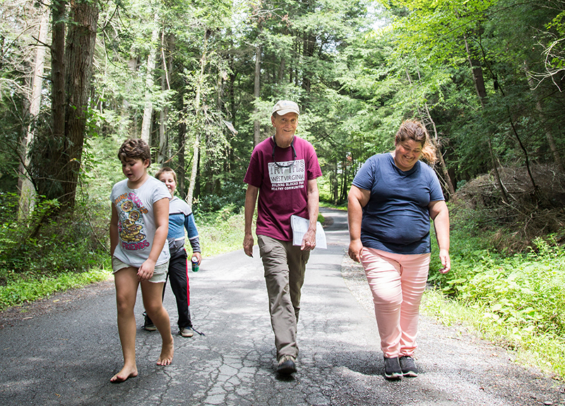 Daniel Doyle (center) walks with neighbor Sandra Keeney and two of her children, Morgan and Aaden  