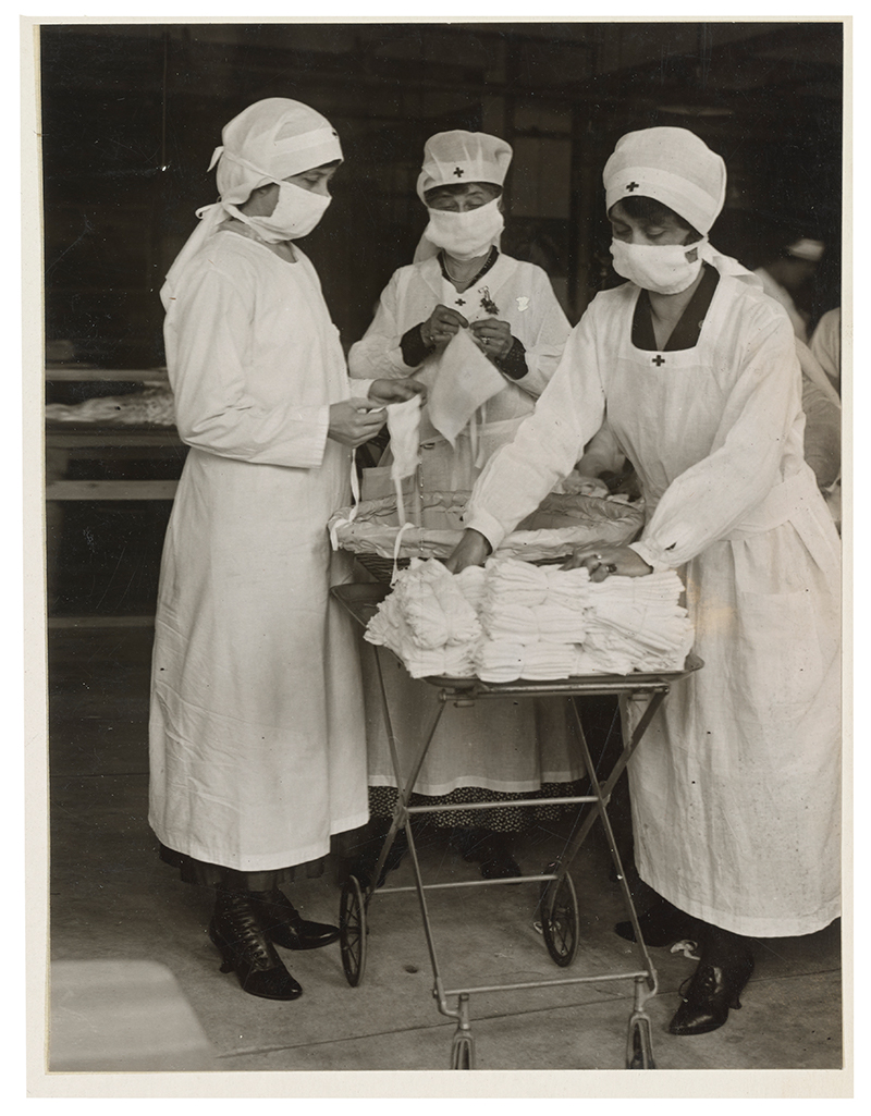 a group of Red Cross workers wrapping masks during the 1918 flu pandemic