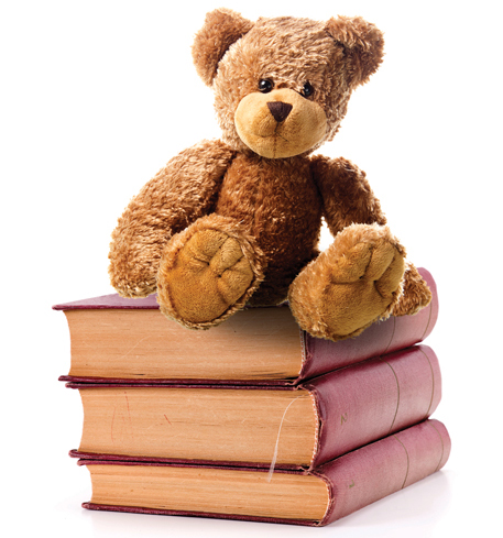 teddy bear sitting on top of a stack of bound journals