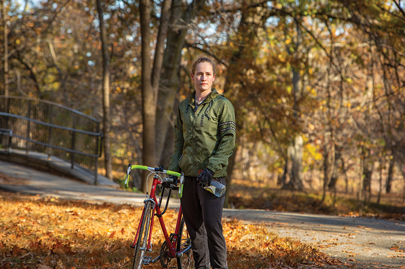 Aliya Feroe satnding with her bike along a bike path
