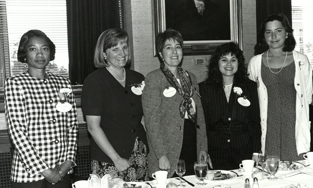 women who have graduated from HMS standing by a table at an alumnae dinner