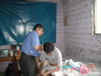 Dr. Epifanio Sanchez, a pulmonologist, makes a post-operative home visit to a drug-resistant TB patient in Lima, Peru. Photo by R. Zegarra courtesy of Socios En Salud 