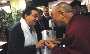 HMS dean Jeffrey Flier (left) greets the Dalai Lama at the conference “Meditation and Psychotherapy.” Flier is wearing a kata, a scarf that one traditionally presents to the Dalai Lama for a blessing when meeting him. 
