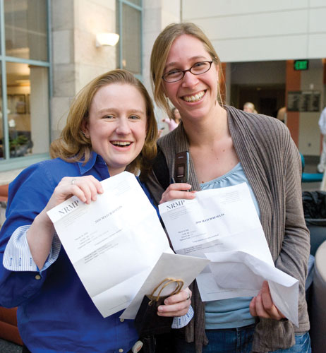 Lauren Gilstrap (left) and Emily Whitesel show off their matches—Gilstrap will be staying local, with a match in internal medicine at Massachusetts General Hospital, while Whitesel will be headed to New York Presbyterian Hospital–Columbia University Medical Center to begin a residency in pediatrics. Photo by Suzanne Camarata.
