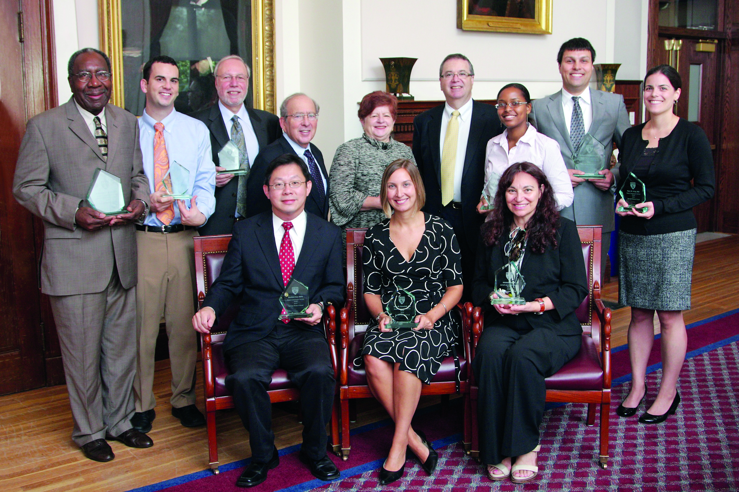 At the Community Service Awards breakfast are (clockwise from far left) Jacques Carter, Brian Block, Kenneth Reich, Bruce Donoff (HSDM dean), Jaine Darwin, Jeffrey Flier (HMS dean), Sabrina Carrie, (accepting the award on behalf of Thierry Pauyo), Vincenzo Bollettino, (accepting the award on behalf of Michael VanRooyen), Sara Selig, Mary Cassesso, Kate Grzesiuk and Jarshin Lin. Photo by Jeff Thiebauth