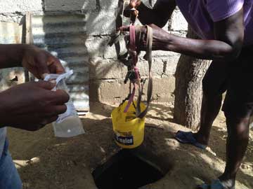 Taking water samples from well in Haiti.  Photo by Wilfredo Matias