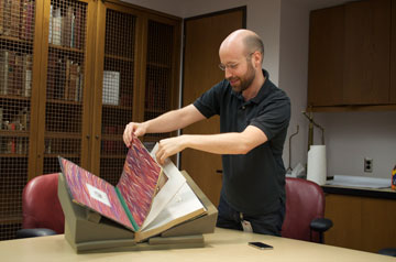 Jason Moschella displaying a Civil War medical text. 