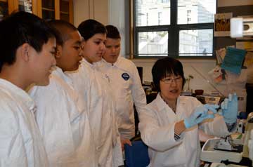 Li Zhang (right), manager of the Histopathology Core Lab, shows students the art of making slides. From left: students William Nguyen, Donald Pepple, Deisi Suarez and Matthew Stephowski. Photo by Lindsey Bourcier 