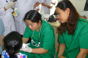 Tran, center, treating a patient at the clinic in Vietnam. Image: Thanh-Nga Tran