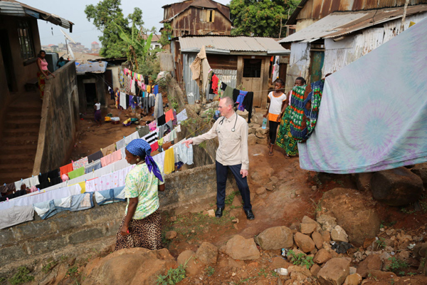 Paul Farmer visits Ebola survivor Yabom Koroma and her family at their home in the Mountain Court section of Freetown, Sierra Leone. December 14, 2015. Image: Rebecca E. Rollins / Partners In Health.