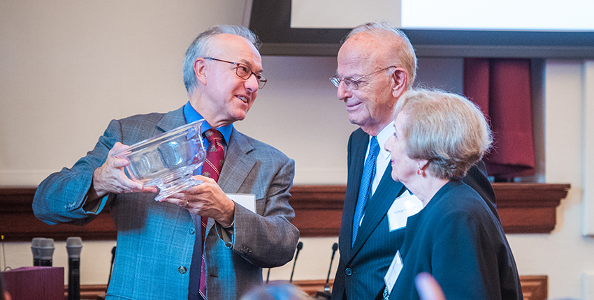 Dean Daley hands crystal bowl to couple