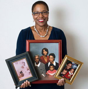 Joan Reede holding family portraits