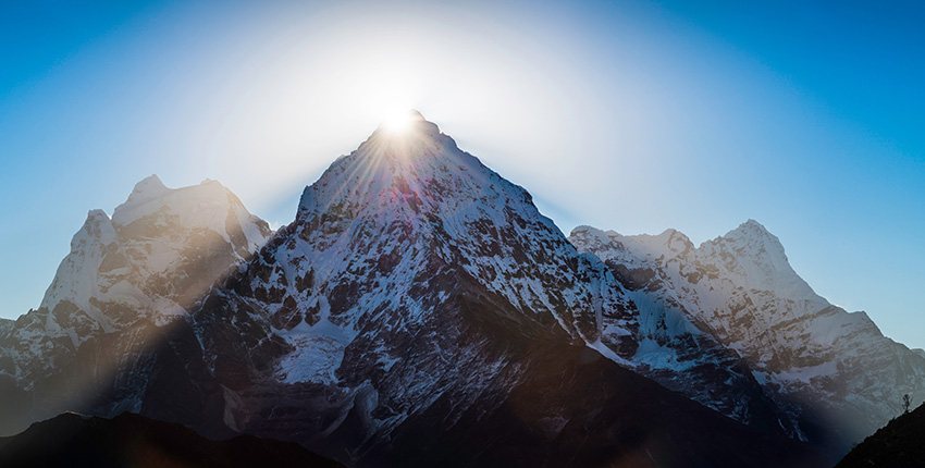 photo of mountain peak with sun shining
