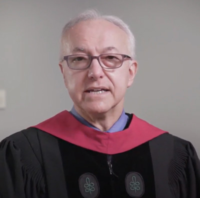 screen shot of dean daley in graduation regalia