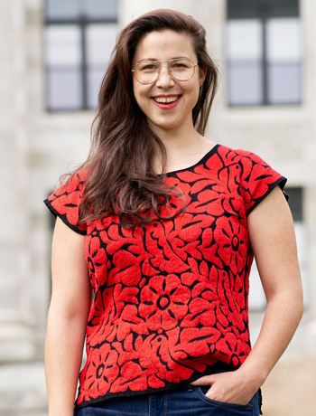 Sedas in red black patterned short sleeve top in front of Gordon Hall blurred out in background