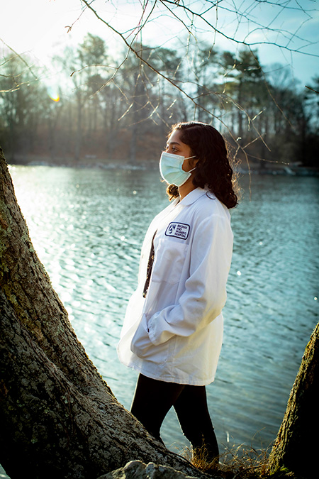 Photo portrait of Srinivasan wearing mask walking by a river