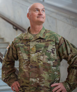 Bain wearing military uniform standing on marble steps with hands on hips