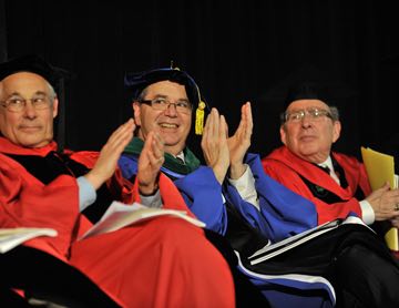 Donald Berwick (left), HMS Dean Jeffrey S. Flier (center) and HSDM Dean Bruce Donoff (right) applaud one of the student speakers.