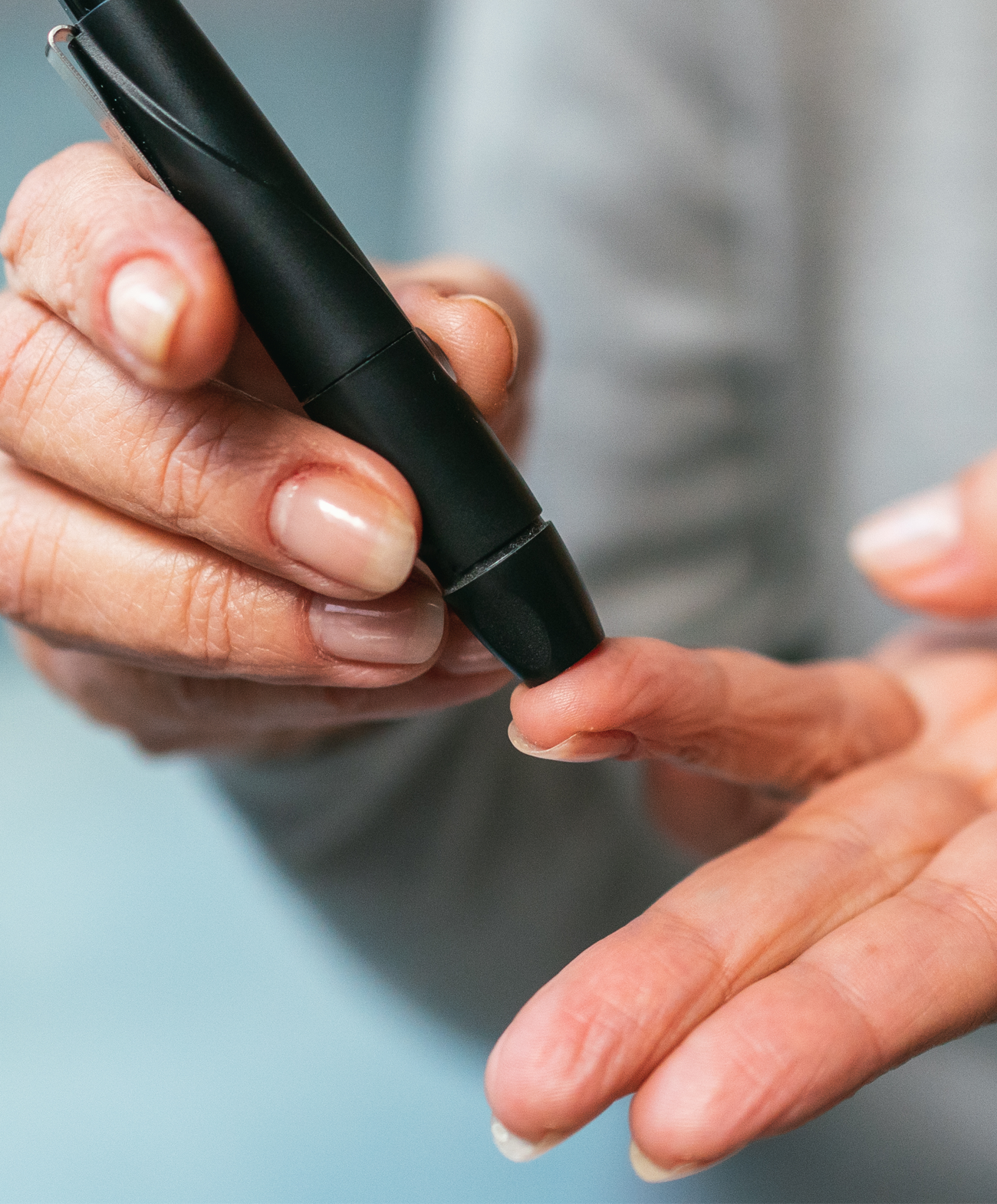 close up of a person puncturing their finger for a diabetes check