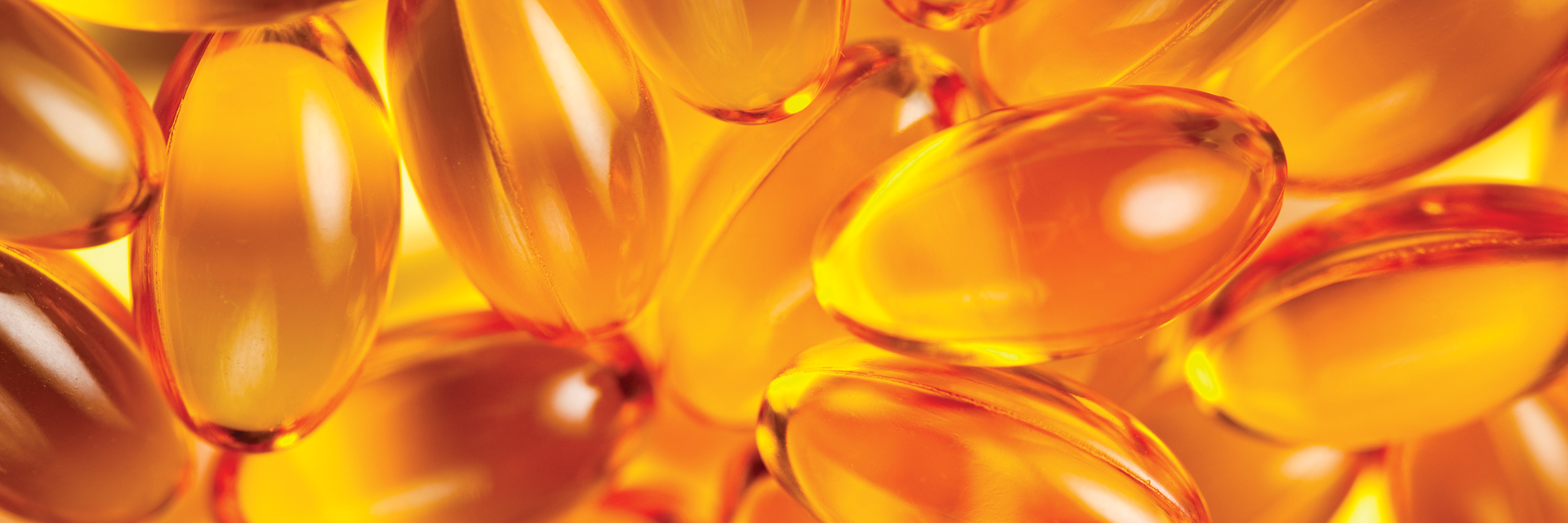 close-up of a quantity of vitatin E gel capsules, golden glow
