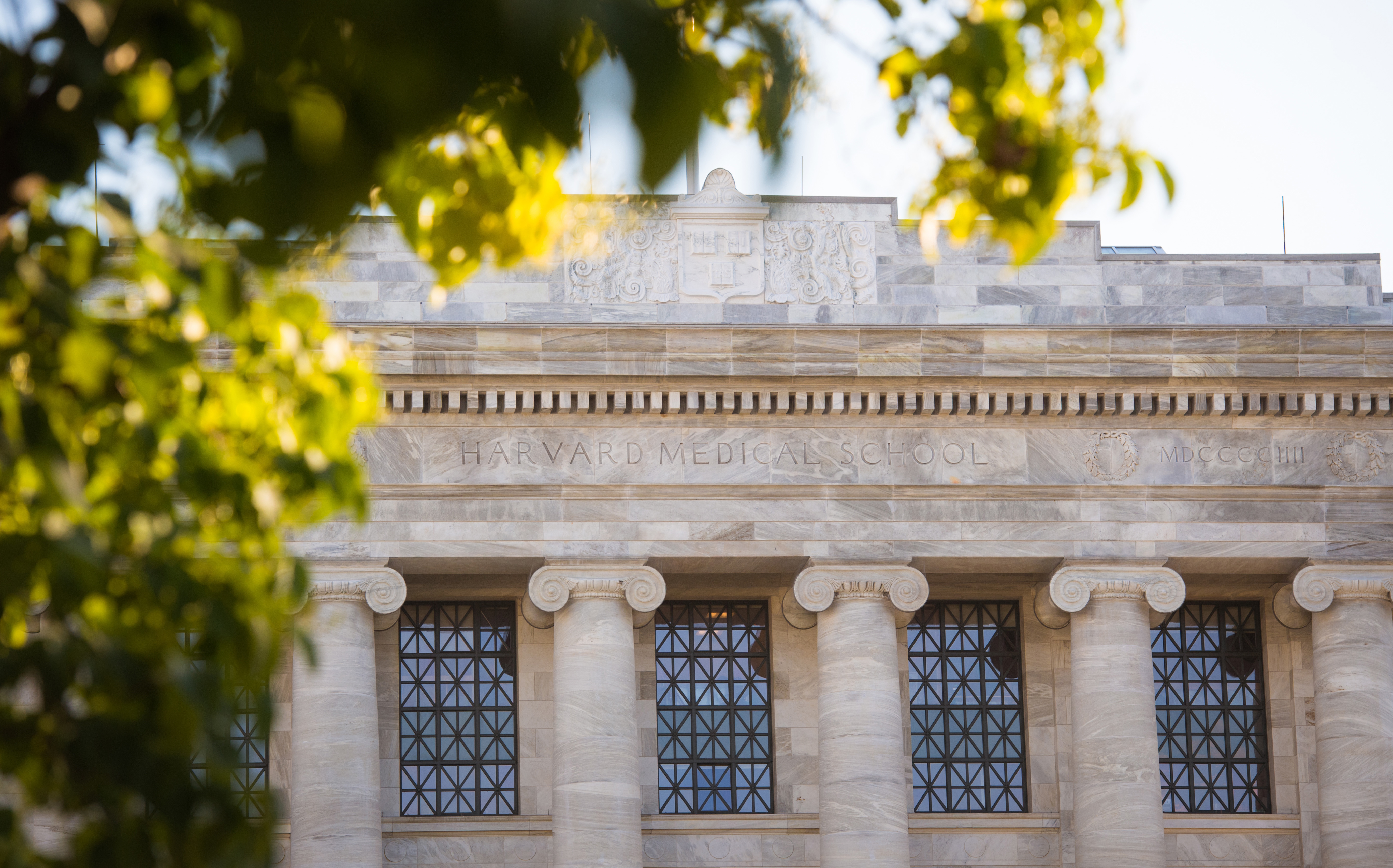 Outdoor photo of Gordon Hall, columned white-marble structure with autumn trees