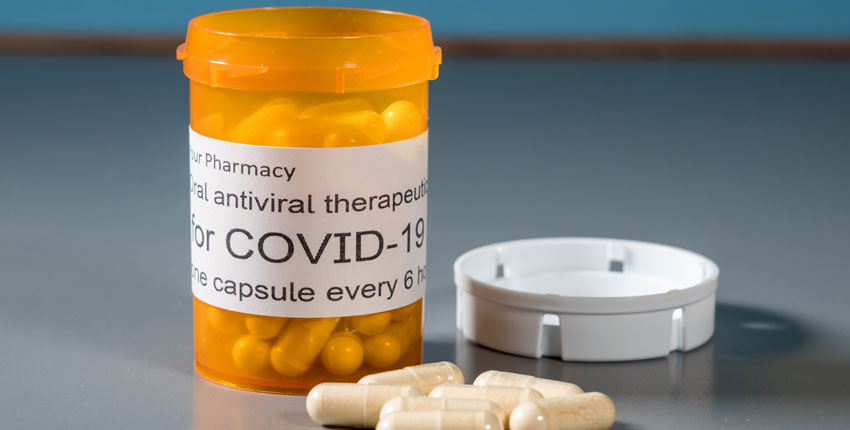 Image of a pill bottle that says COVID Rx with some pills near it
