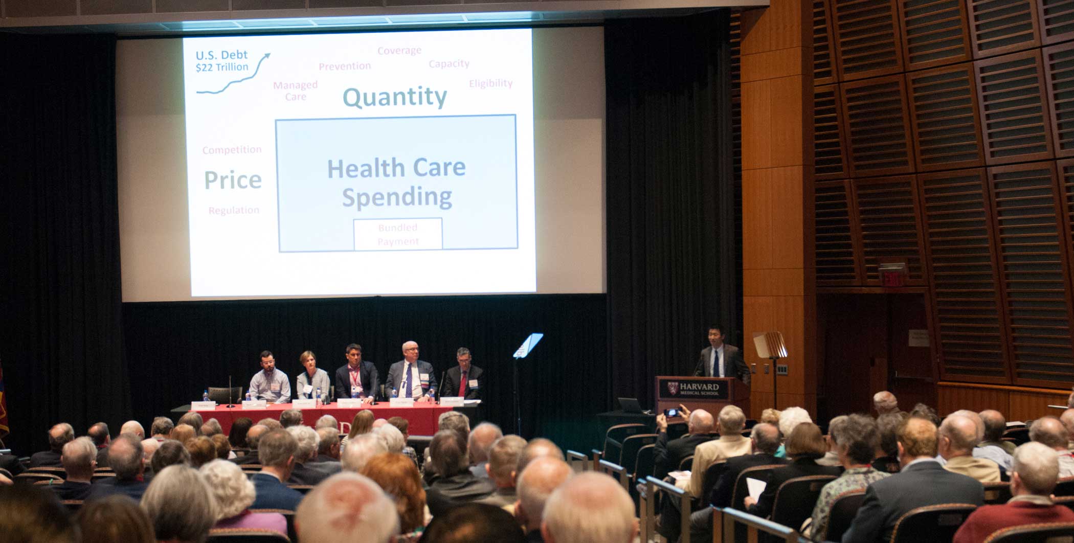 Song, far right, presents while other panelists look on.  