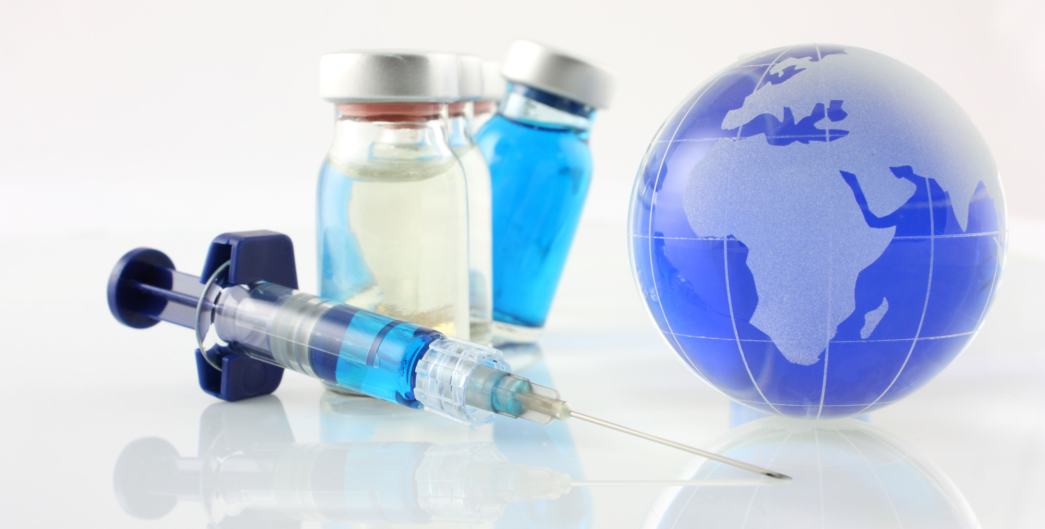 Image with syringe, vaccine bottles and a small Earth globe