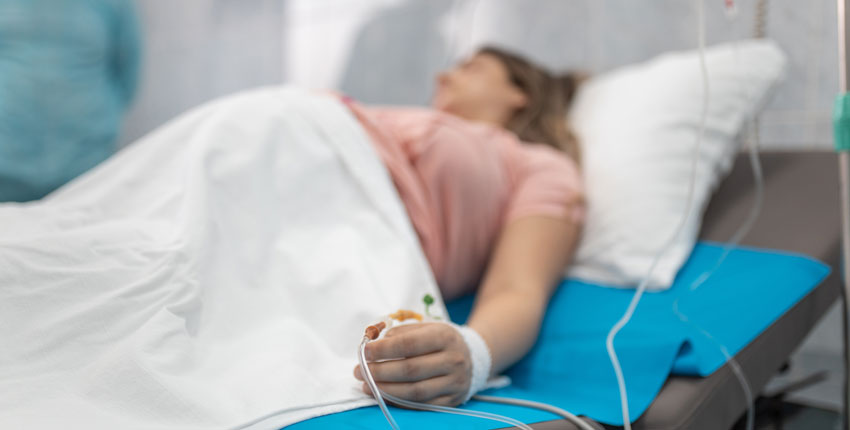 Out of focus image of a pregnant woman on a hospital bed with IV 