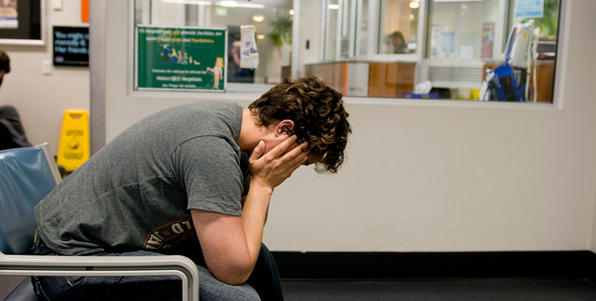 Stock image of a young man with his head in his hands 