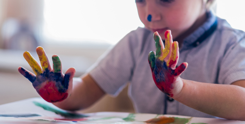 A young child's paint-covered hands.