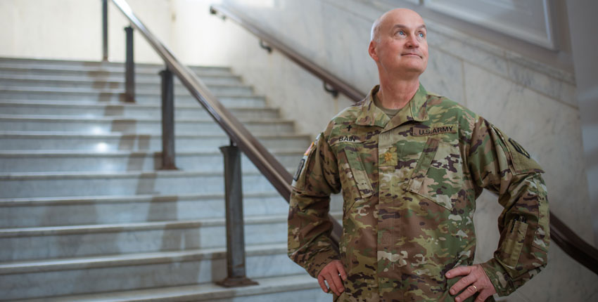 Bain wearing military uniform standing on marble steps with hands on hips